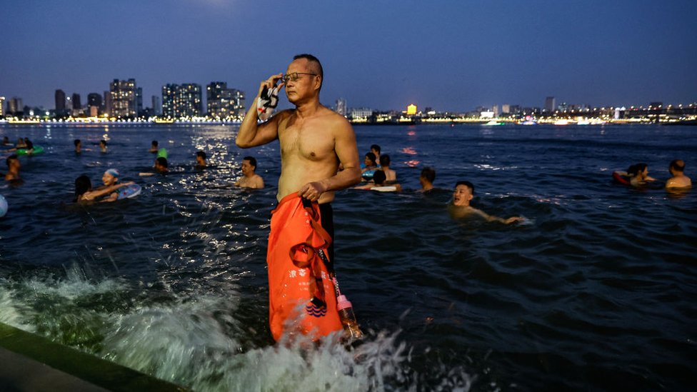 Kina i toplotni talas: Vlasti raketama nastoje da izazovu padavine kako bi se izborile sa velikim sušama 1 People swim in the intersection of the Han and Yangtze rivers during the heatwave in Wuhan, Hubei province on 10 August