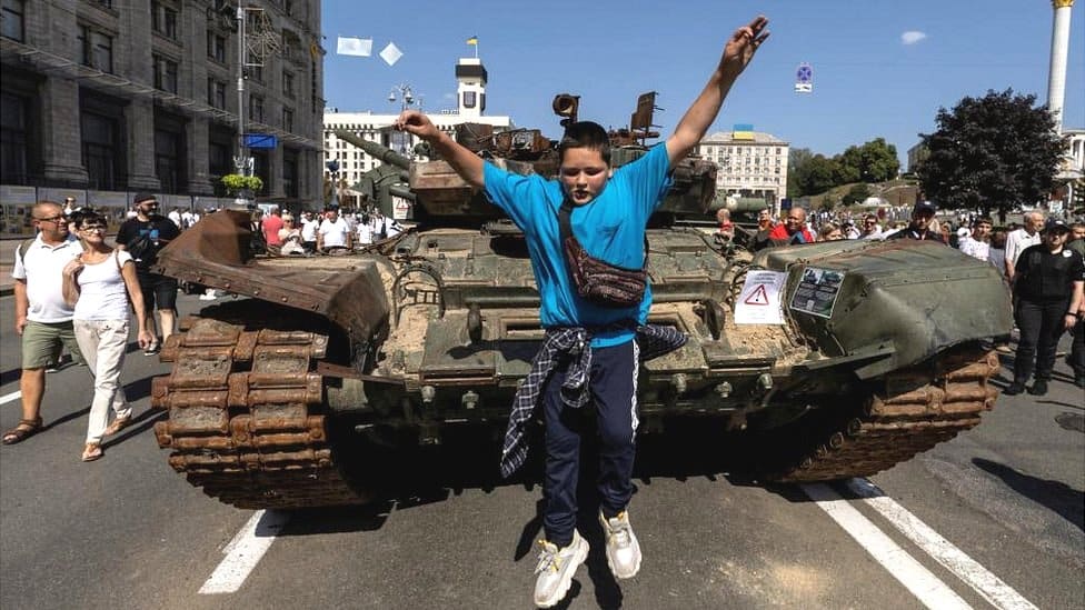 Ukrajina i Rusija: Proterivanje ruske vojske biće seizmički zadatak za Kijev 1 A boy jumps from a tank at an exhibition of destroyed Russian military vehicles and weapons, dedicated to the upcoming country's Independence Day, amid Russia's attack on Ukraine, in the centre of Kyiv, Ukraine August 21, 2022