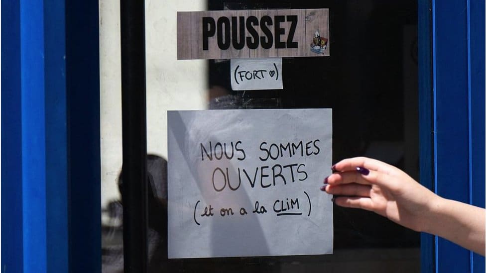 A handwritten sign on a closed shop door in France