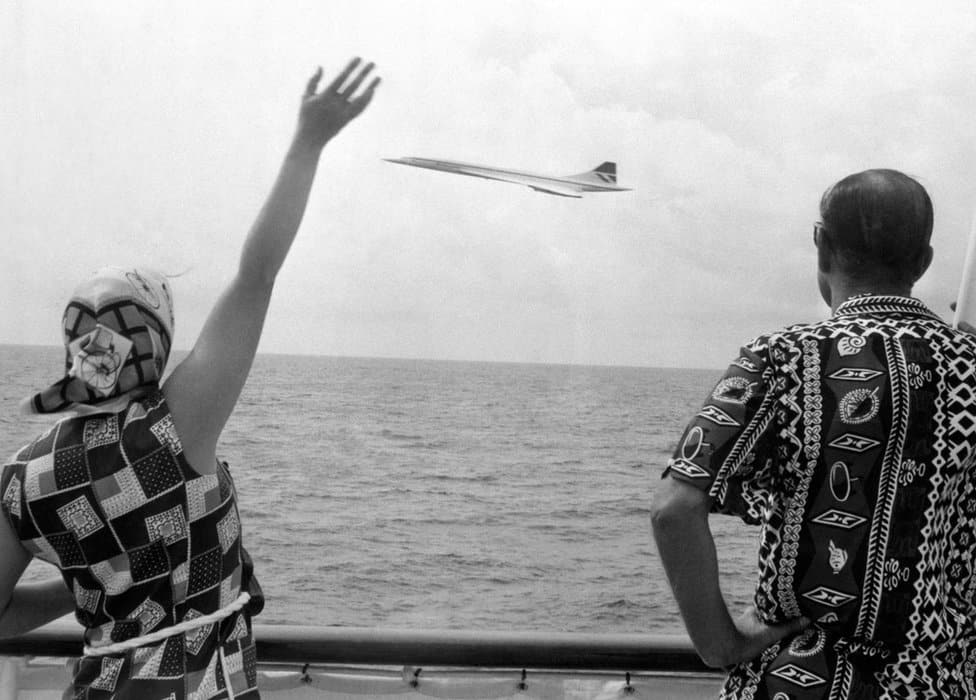 Kraljica Elizabeta Druga: Život u fotografijama 24 Queen Elizabeth II and the Duke of Edinburgh wave as Concorde flies by the Royal Yacht Britannia as the royal couple neared Barbados
