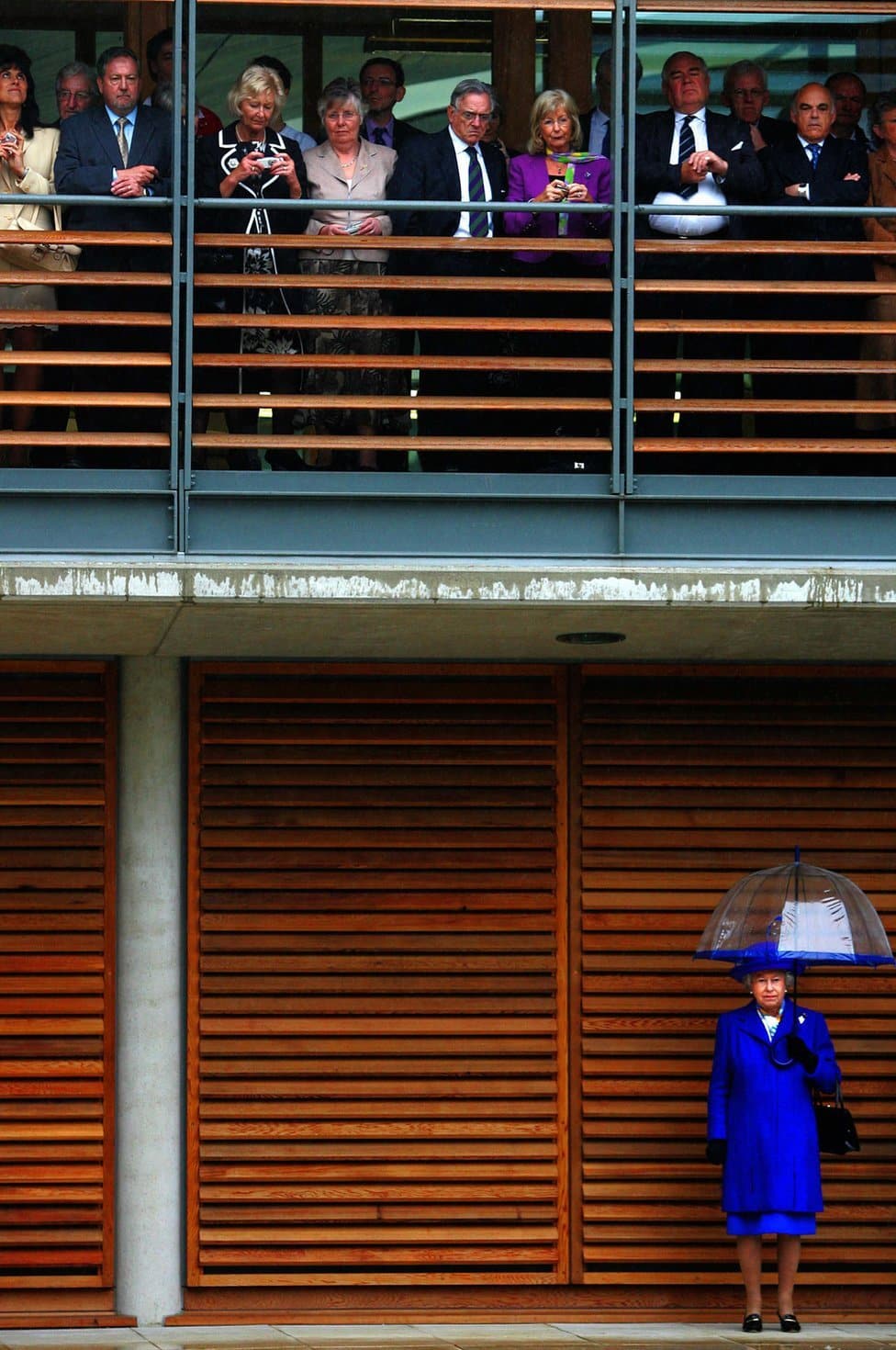 Kraljica Elizabeta Druga: Život u fotografijama 37 Queen Elizabeth II stands in the rain as guests take shelter at the opening of the Lawn Tennis Associations new headquarters in Roehampton, London, 2007