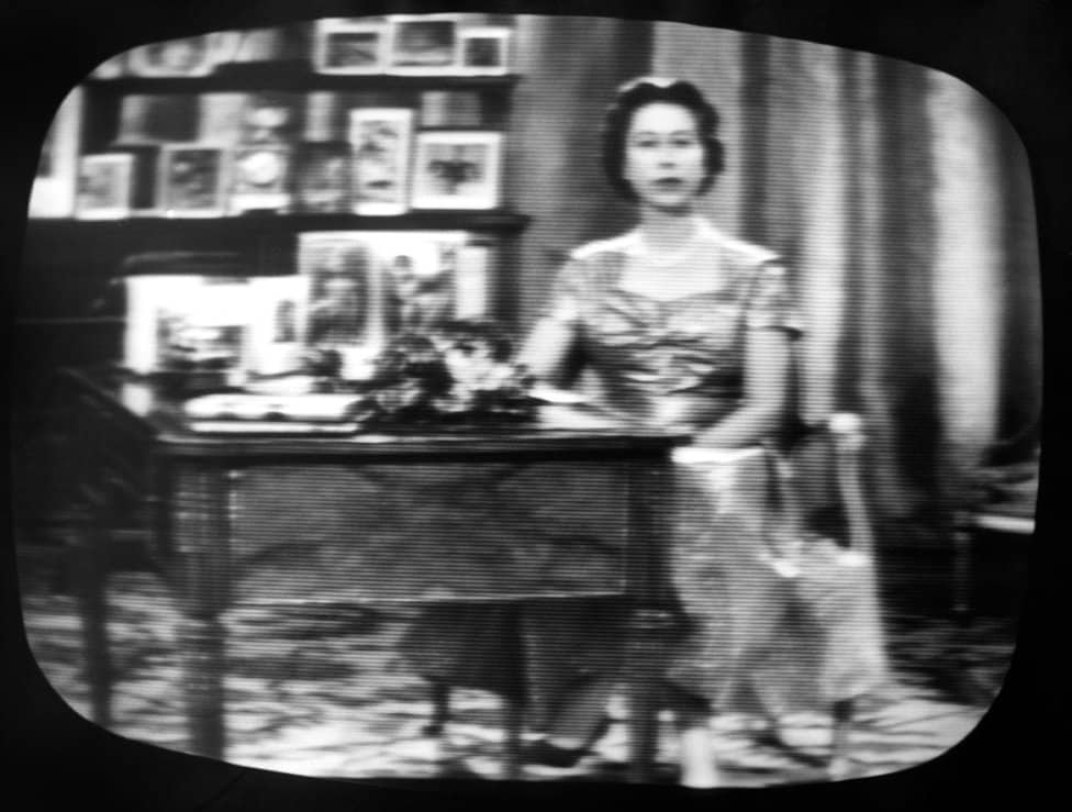 Kraljica Elizabeta Druga: Život u fotografijama 15 The Queen seen on a television screen as she concludes what became her traditional Christmas day broadcast to her people, which was televised in 1957 for the first time and carried by both the BBC and ITV.