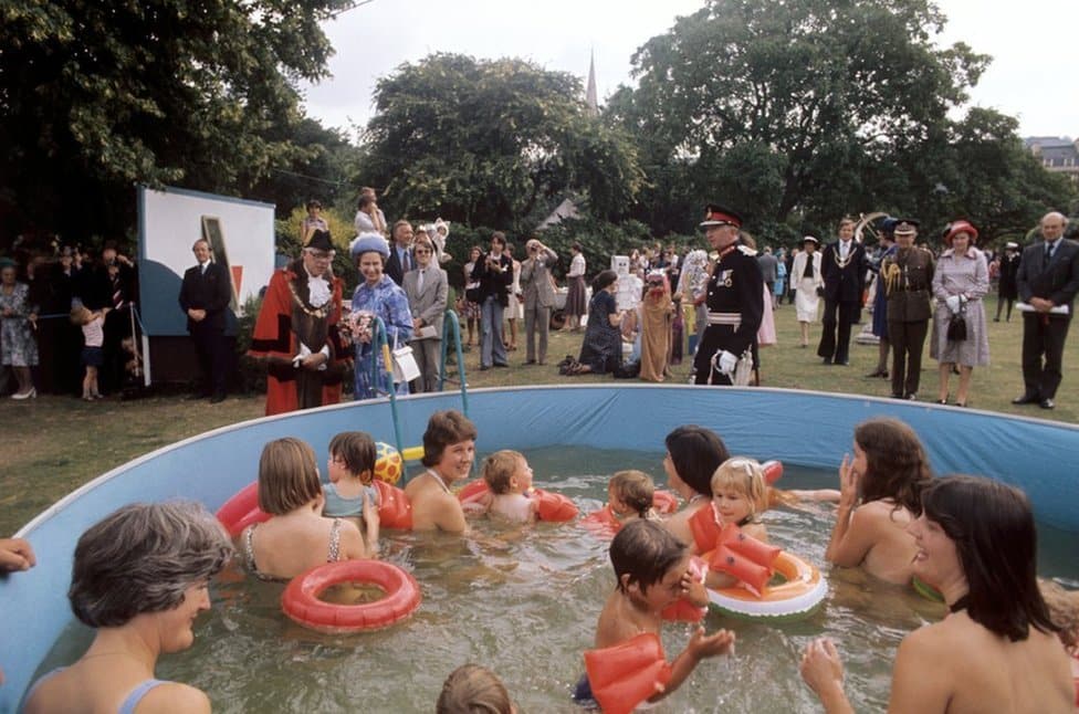 Kraljica Elizabeta Druga: Život u fotografijama 23 Queen Elizabeth II watches bathers in a pool at Parade Gardens, Bath, during her Silver Jubilee tour of Great Britain.