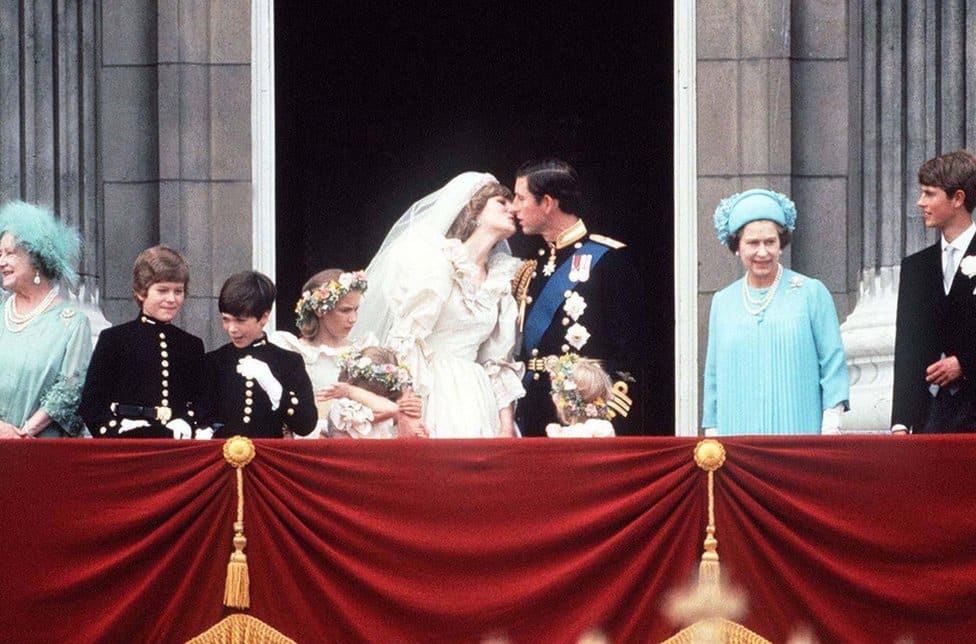 Kraljica Elizabeta Druga: Život u fotografijama 27 Prince Charles And Princess Diana kissing on The balcony of Buckingham Palace, 29 July 1981. They are surrounded by their bridesmaids and pageboys as well as Queen Elizabeth II, Prince Edward and the Queen Mother.