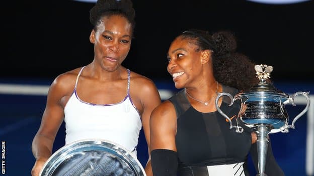 Venus Williams and Serena Williams pose with their trophies at the Australian Open after the 2017 final.