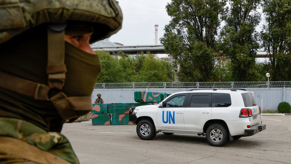 A car transporting members of the International Atomic Energy Agency (IAEA) expert mission drives past a checkpoint