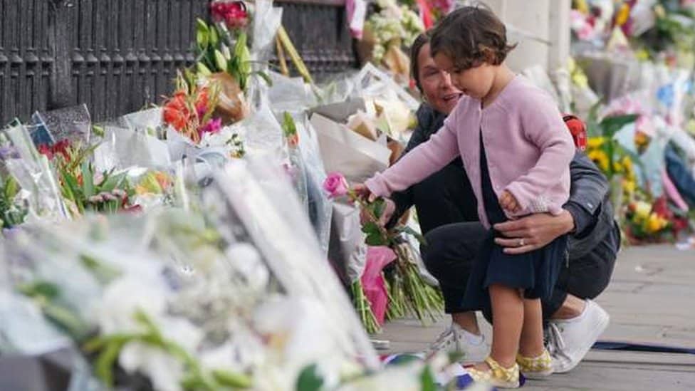 Kraljica Elizabeta Druga: Hiljade ljudi položilo cveće ispred Bakingemske palate, svetski lideri odaju počast 4 dete ostavlja cveće