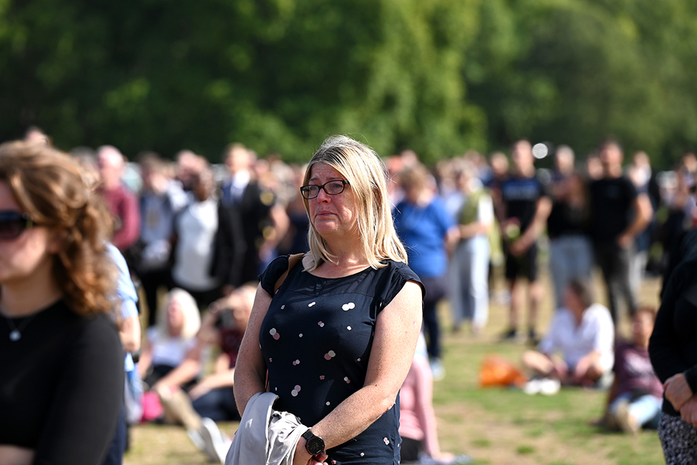 A tearful mourner watch's the procession for the Lying-in State of Queen Elizabeth II at the Hyde Park screening site on 14 September 2022 in London