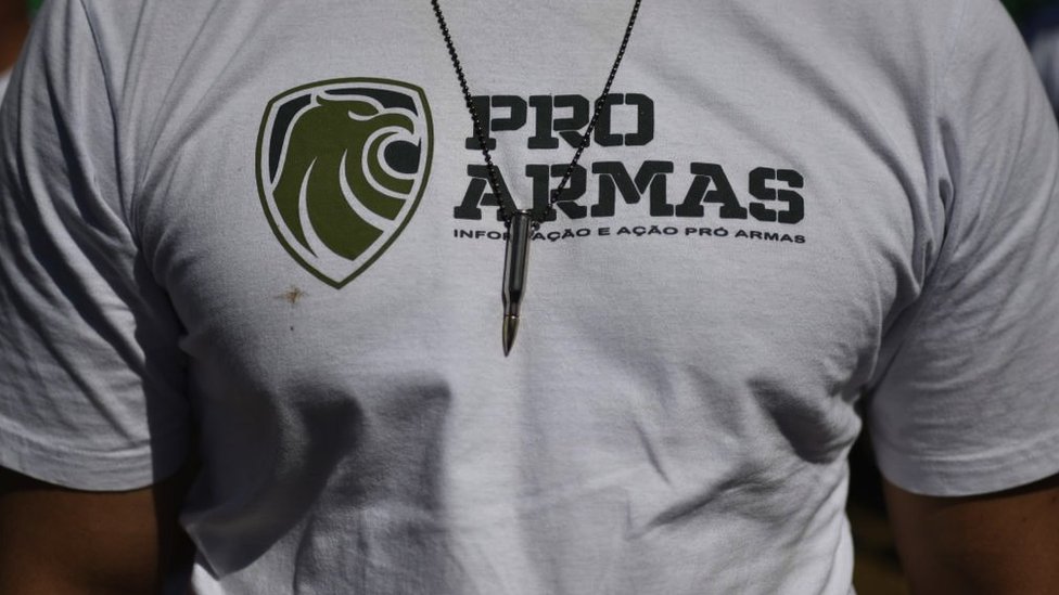A man wears a pro-gun t-shirt with a necklace with bullet pendant