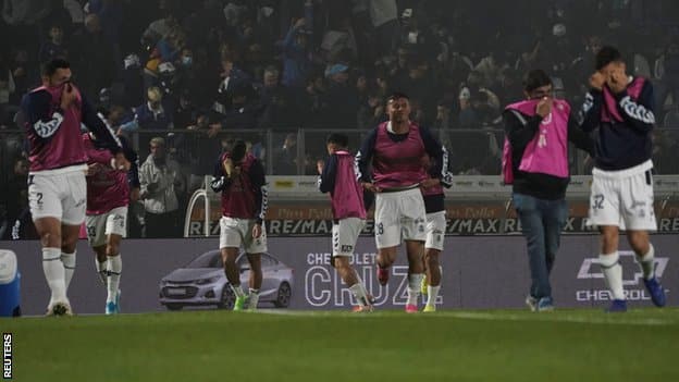 Argentina, fudbal i nasilje: Navijač preminuo na utakmici Boke Juniors i Himnasije 2 Players cover their faces to stop being affected by tear gas