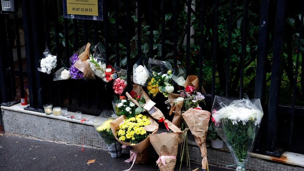 Na fotografiji su buketi cveća ostavljeni ispred zgrade u Parizu 17. oktobra 2022. godine, gde je živela 12-godišnja po imenu Lola, tri dana nakon što je otkriveno njeno beživotno telo.