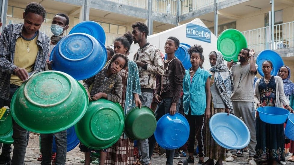 Afrika, Etiopija i građanski rat: Hijene kidaju leševe žrtava brutalnih sukoba 2 People who fled the violence in Ethiopia's Tigray region wait to receive injeras, Ethiopia's staple food of sour fermented flatbread, from their kitchen as only meal of the day at May Weyni secondary school, now hosting 10500 displaced people as an IDP camp, in Mekele, the capital of Tigray region, on June 19, 2021