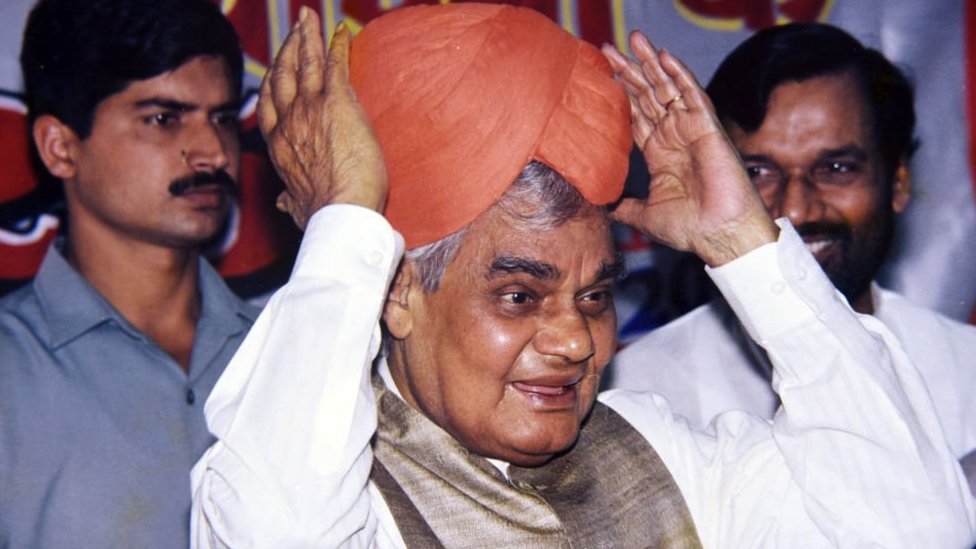 Indian Prime Minister Atal Behari Vajpayee holds a turban presented to him as a mark of respect during a en event in New Delhi in 2000