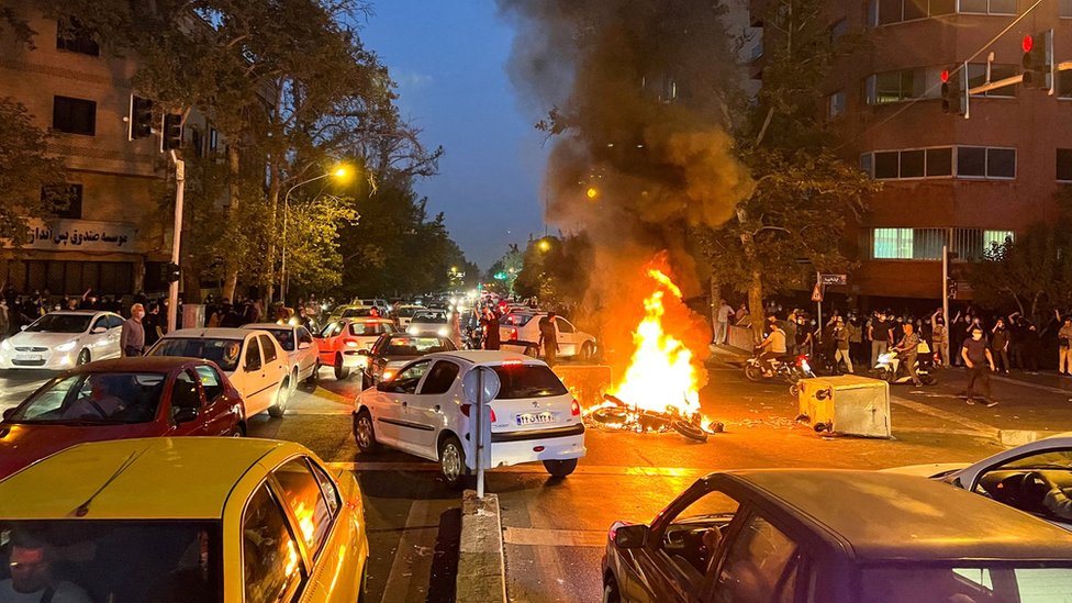 File photo showing a police motorcycle on fire during a protest over the death of Mahsa Amini in Tehran, Iran (19 September 2022)