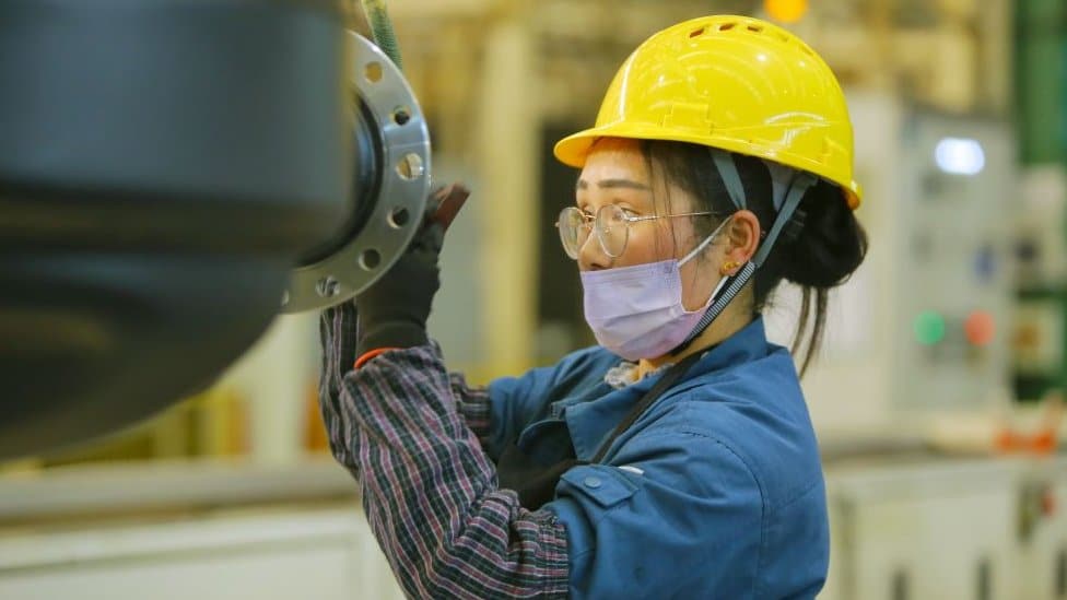 A quality inspector makes the final inspection of a Daimler axle housing before packing it for export at the Daimler axle housing production plant in Qingdao, Shandong Province, China, January 20, 2022