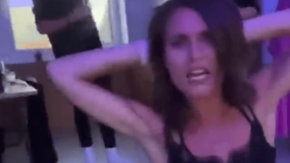 Finnish prime minister is seen dancing on floor in black top and white jeans