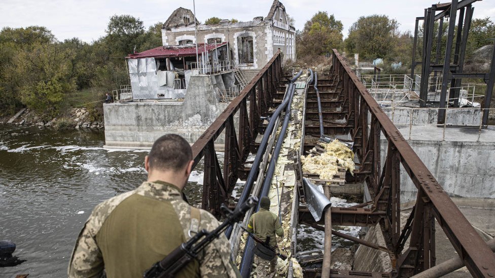 Ukrainian soldiers cross damaged bridge in the recaptured town of Velyka Oleksandrivka in Kherson region,