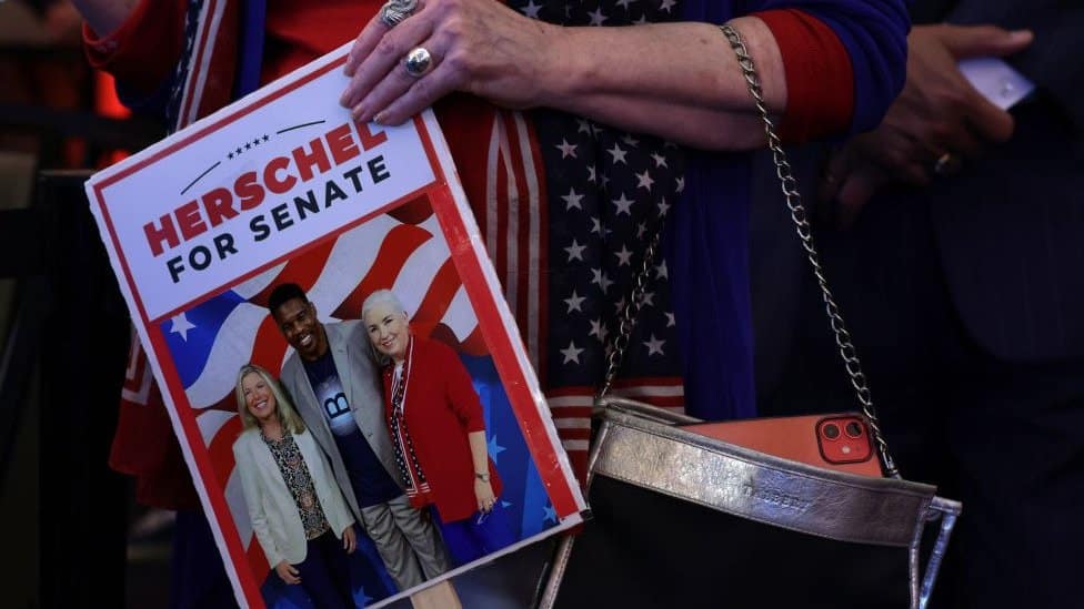 A supporter holds a picture of Republican U.S. Senate candidate Herschel Walker during an election night event on November 8