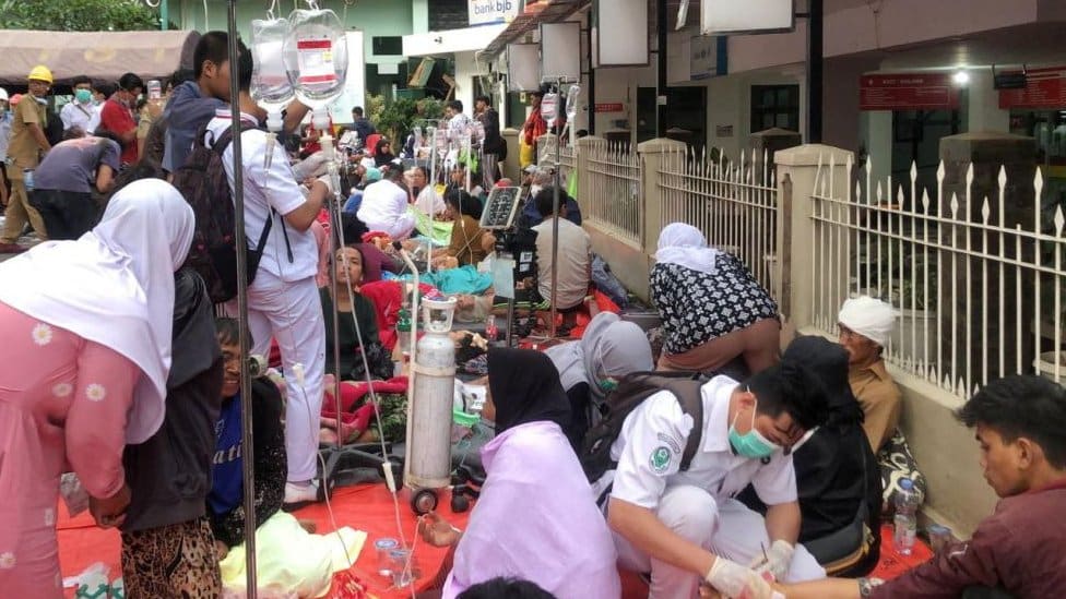 People are treated outside a hospital building in Cianjur, West Java