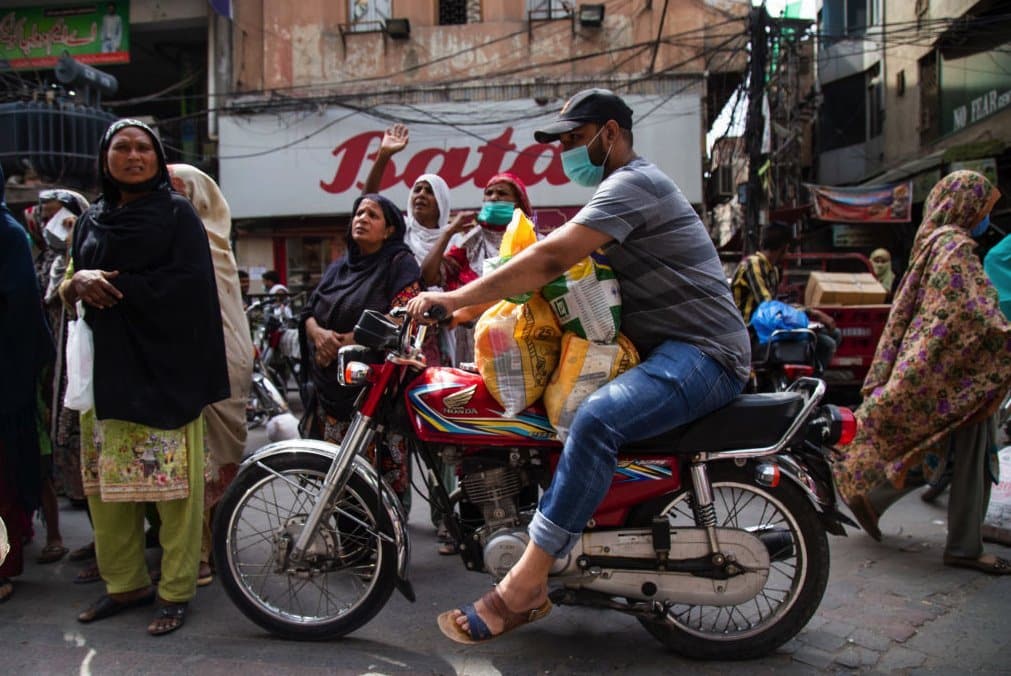 LAHORE, PAKISTAN - APRIL 14: People wait outside a shop to receive food rations on the first day of Ramadan on April 14, 2021 in Lahore, Pakistan. Several cities in Pakistan went back under partial lockdowns ahead of Ramadan due to an uptick in coronavirus cases. Mosques in Pakistan will remain open during the holy month. (Photo by Betsy Joles/Getty Images)