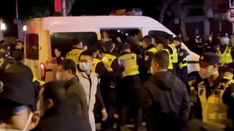 Police officers detain people during a protest against Covid restrictions in Shanghai
