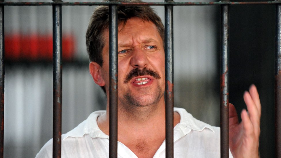 Russian arms dealer Viktor Bout speaks to the press from behind his cell bars of the criminal court detention centre in Bangkok in April 2008