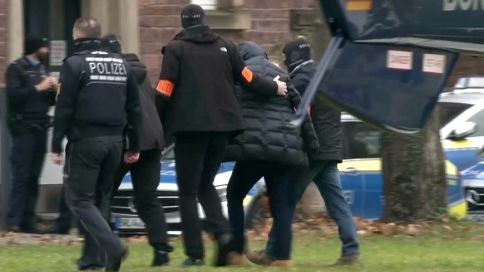 German police lead away member of group accused of plotting coup
