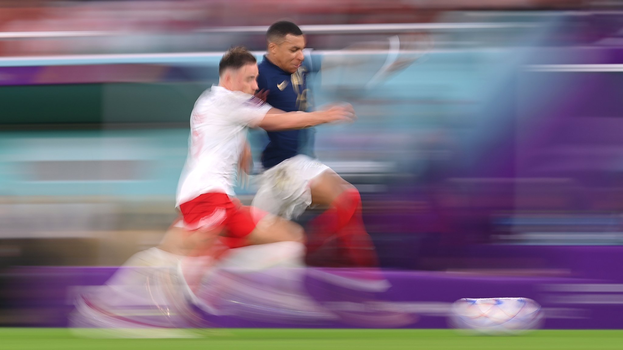 Kylian Mbappe and Matty Cash sprinting along the touchline - the blurred picture suggesting how fast they are running