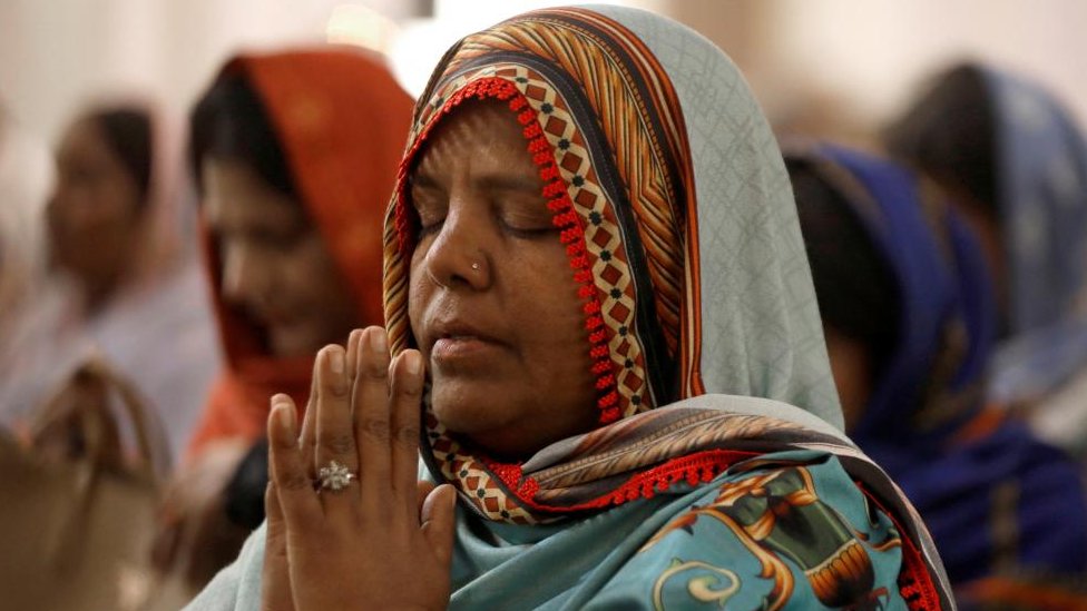 A woman prays in a church in Pakistan