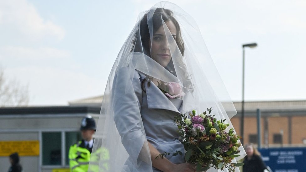 Stella Assange poses for a photo wearing a wedding dress designed by Dame Vivienne Westwood