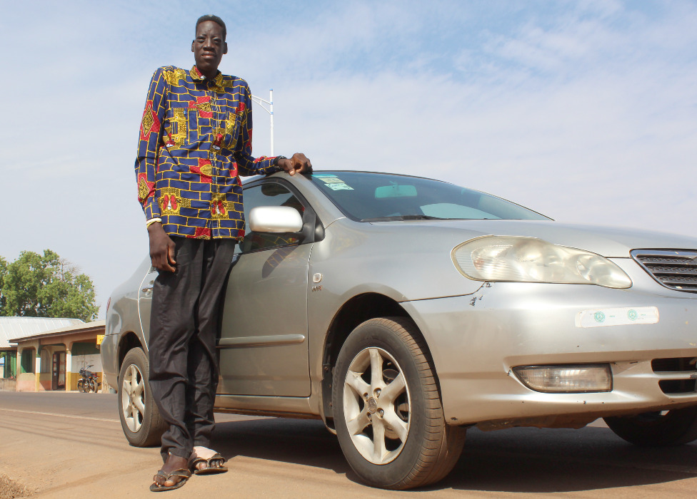 Afrika i poremećaji ljudi: Da li je ovo najviši čovek na svetu 6 Awuche next to a car