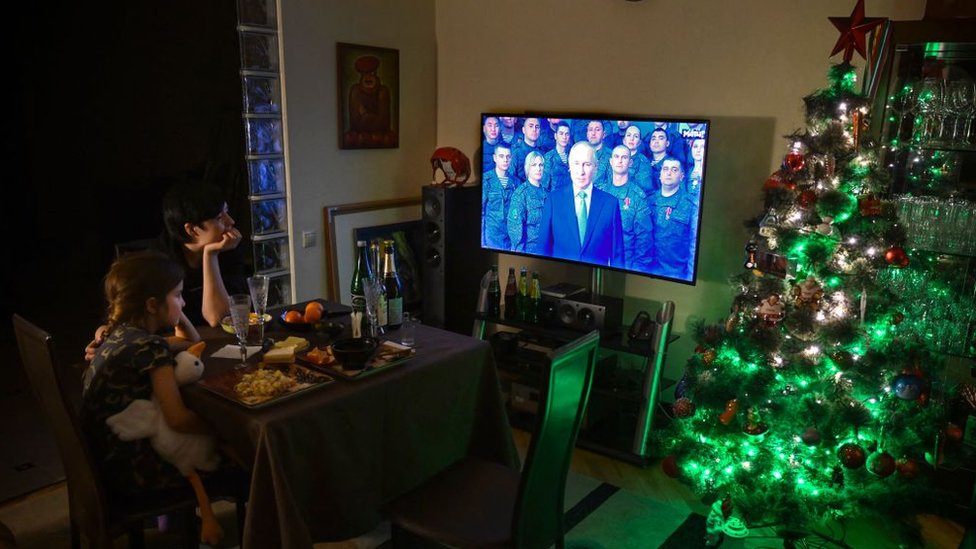 Rusija i Ukrajina: Nova godina u Putinovoj Rusiji - ništa nije normalno 2 A family watches President Putin's speech