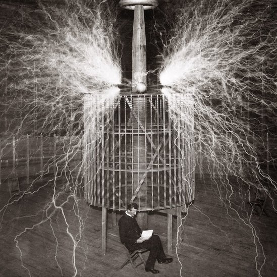 Nikola Tesla (1856-1943), Serbian-American physicist sitting in his Colorado Springs laboratory with his "Magnifying transmitter" - 1899