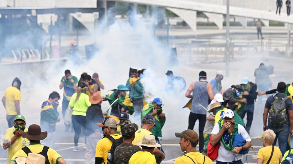Supporters of Brazilian former President Jair Bolsonaro clash with the police during a demonstration outside the Planalto Palace in Brasilia on January 8, 2023. -