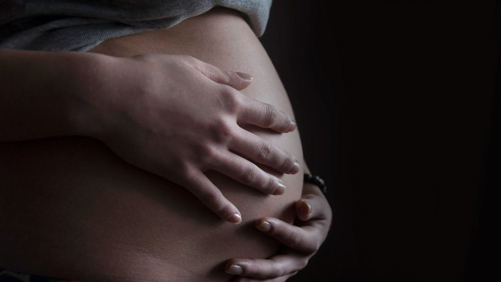 Pregnant woman with hands on her bump