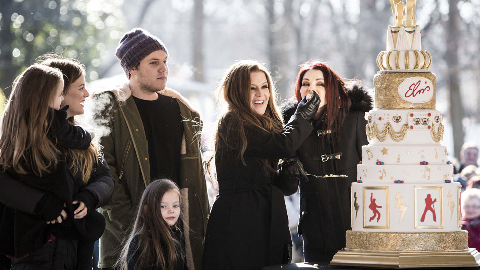 Lisa Marie Presley's children, left, watch as she feeds a piece of birthday cake to Priscilla Presley, far right, during the 80th birthday celebration for Elvis Presley at Graceland on Thursday, Jan. 8, 2015.