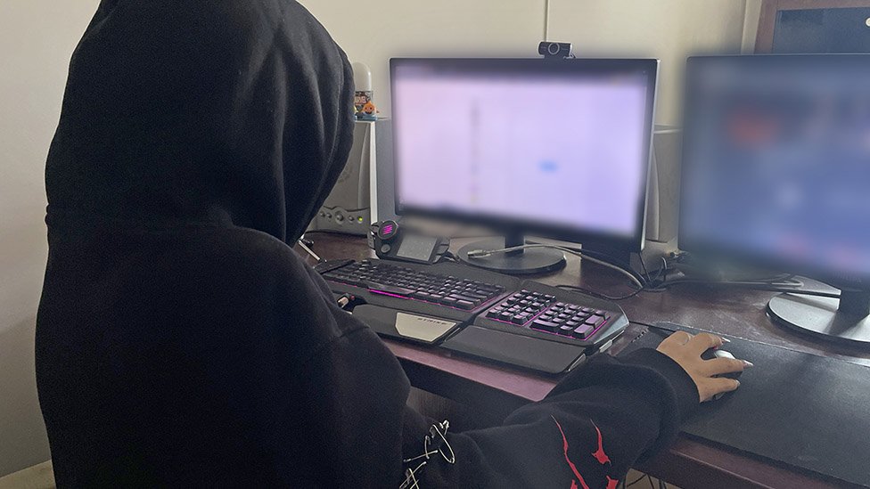 Endrju Tejt: Devojke iz Rumunije objašnjavaju kako im se obraćao preko društvenih mreža 4 Young person wearing hoodie looks at computer screens