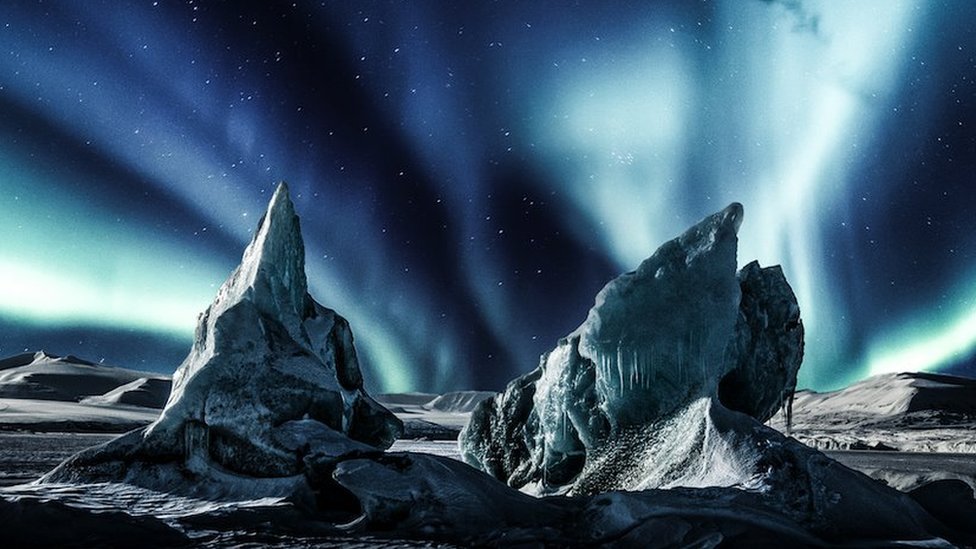 Ice mountains of Svalbard, Norway, with the aurora borealis illuminating the night sky