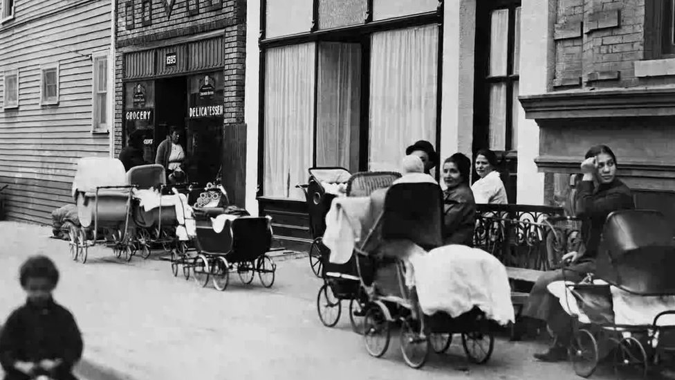 Women and men with prams in front of the clinic