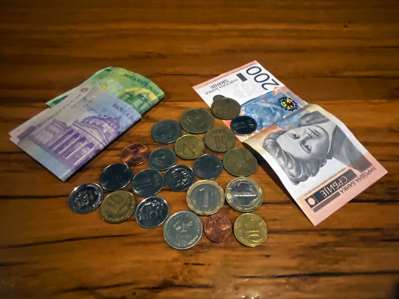 Rumunske, hrvatske, albanske, bugarske, makedonske i mađarske kovanice na stolu, sa paprirnim dinarima i rumunskim lejima