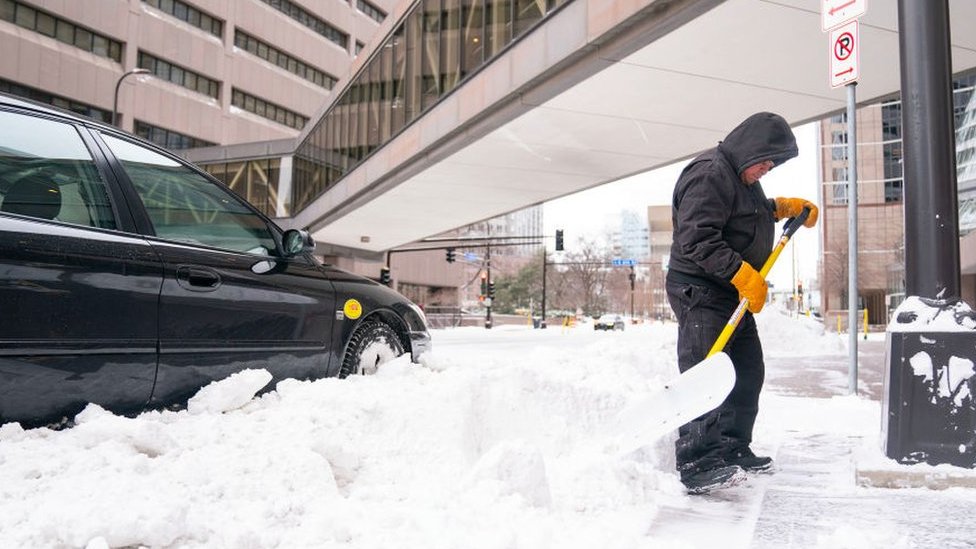 Luis Lara clears snow off of sidewalks Wednesday, Feb. 22, 2023 in downtown Minneapolis