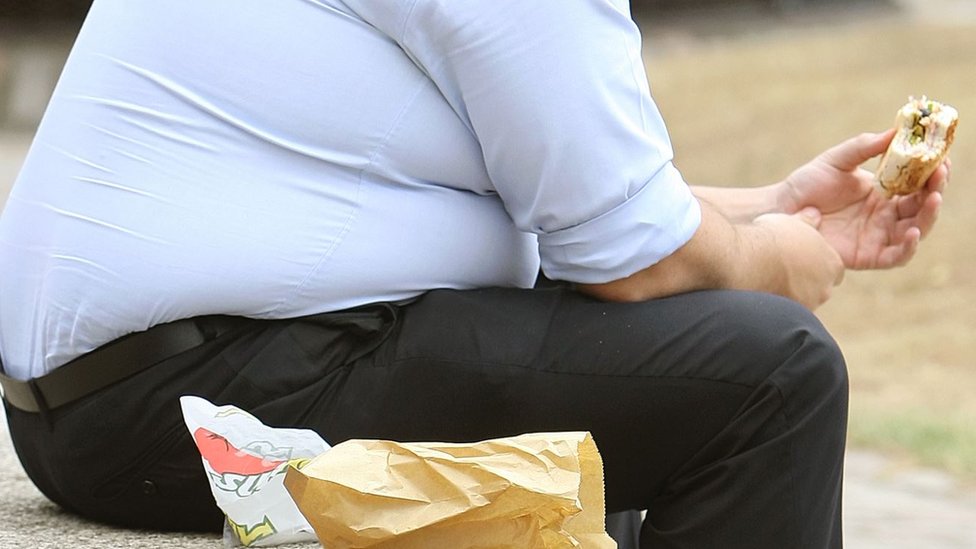 Čovek jede hamburger