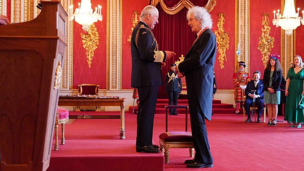 King Charles chats with Brian May after knighting him at Buckingham Palace