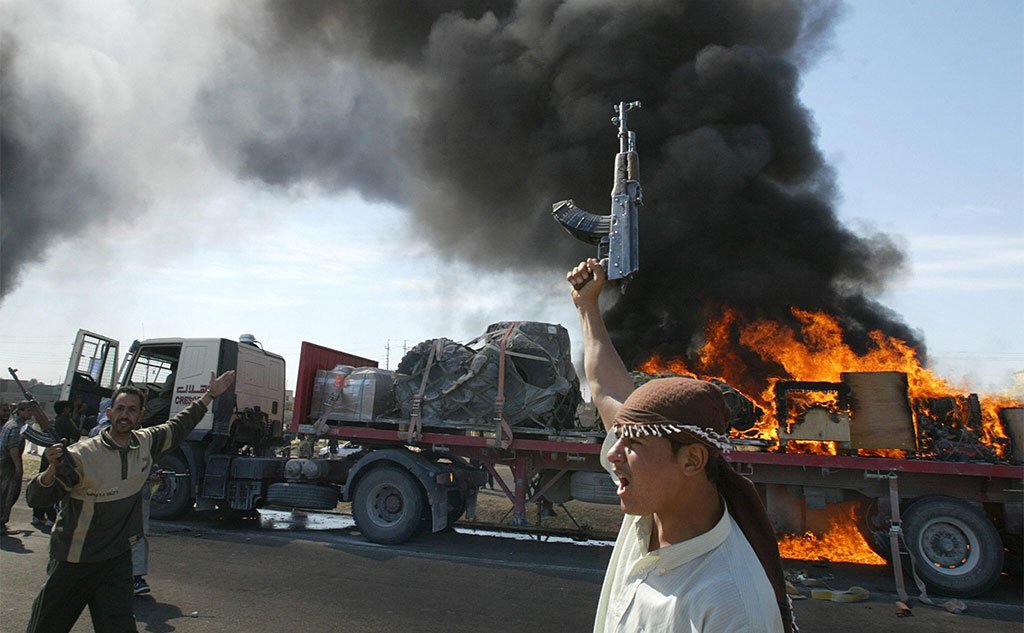 Irački pobunjenici iz redova suni muslimana ispred američkog konvoja u plamenu u predgrađu Faludže 2004