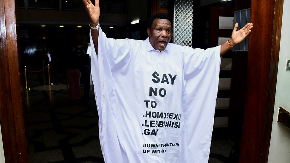 LGBT, Uganda i zakoni: Doživotni zatvor za one koji se izjasne kao homoseksualci 1 Ugandan MP John Musira dressed in an anti-gay gown gesturing as he leaves the chambers during the debate of the Anti-Homosexuality bill