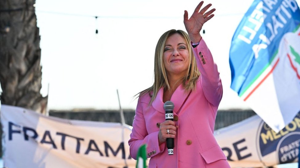 Giorgia Meloni waves as she delivers a speech on September 23, 2022 at the Arenile di Bagnoli beachfront location in Naples