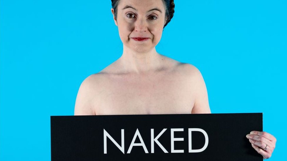 Victoria Bateman holding a banner which reads naked