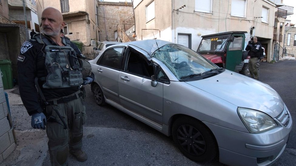 Izrael i Palestinci: Iz Libana ispaljene desetine rakete na Izrael, optužbe na račun Hamasa 2 A member of the Israeli security forces stands next to a car in the northern Israeli village of Fassuta that was damaged by a rocket fired from Lebanon (6 April 2023)