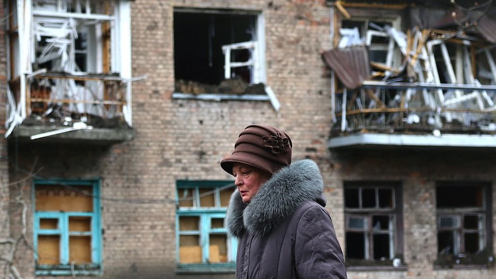 One of the few remaining villagers walks past a building damaged by recent shelling during heavy fighting at the frontline of Bakhmut and Chasiv Yar, in Chasiv Yar, Ukraine, April 12, 2023. REUTERS/Kai Pfaffenbach TPX IMAGES OF THE DAY