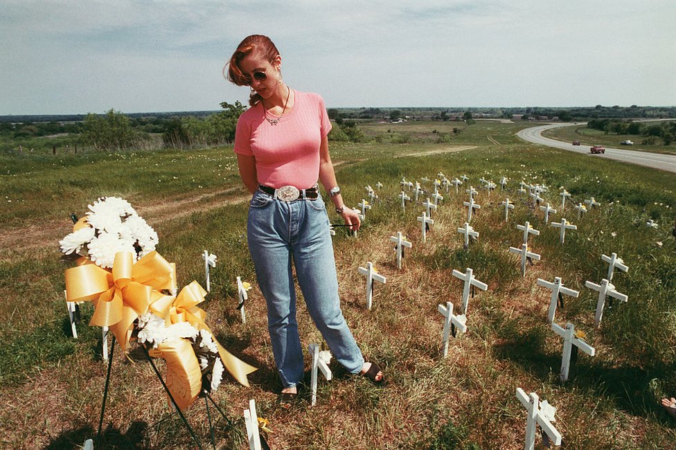 A woman stands among the graves of victims of the Waco tragedy